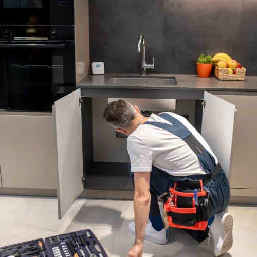back-view-man-crouching-near-kitchen-sink