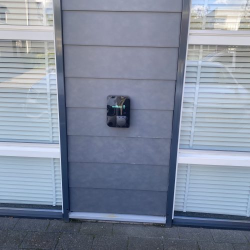 Nieuwe laad paal tegen een grijze muur